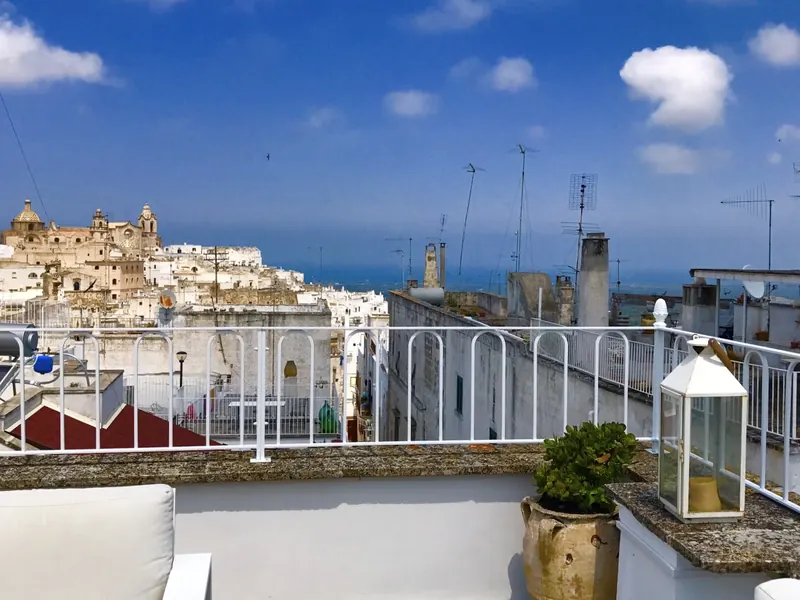 Casa Palmira terrace with a lantern and potted plant above the old town