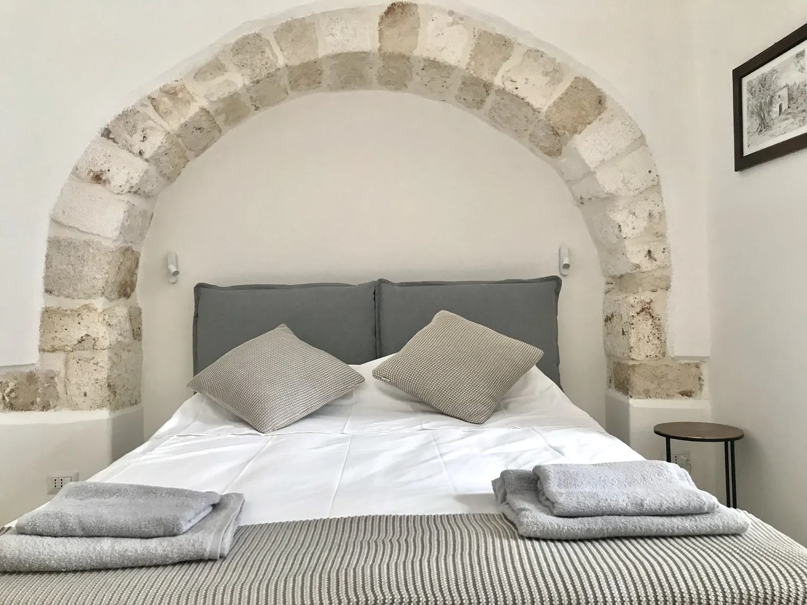 Casa Rita bed set beneath a traditional stone arch